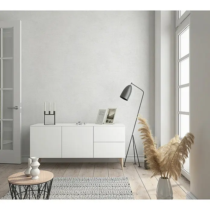 Marburg Sand & Stones Vliestapete Shades - Grauweiß, Uni, 10,05 x 0,53 m - Modernes Wohnzimmer mit weißem Sideboard, Stehlampe und dekorativen Elementen für ein stilvolles Ambiente.