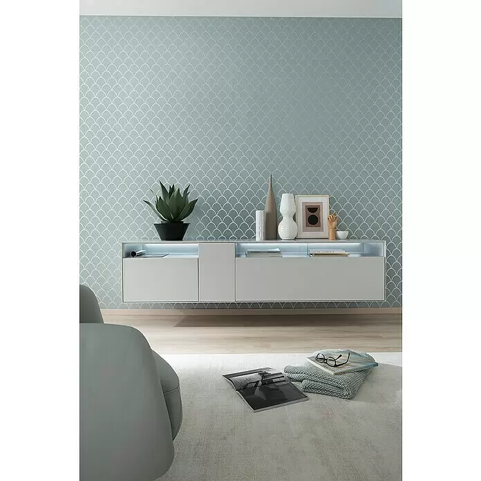 SCHÖNER WOHNEN-Kollektion New Spirit Vliestapete - Grün, Grafisch, 10,05 x 0,53 m - Moderne hellgraue schwebende Medienkonsole im Wohnzimmer, mit integrierter Beleuchtung und Dekoobjekten.