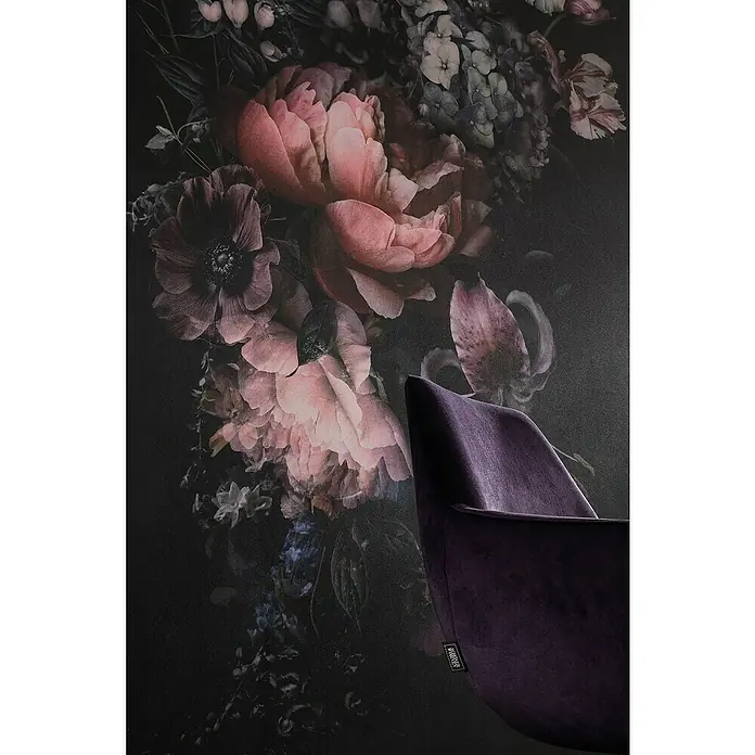 SCHÖNER WOHNEN-Kollektion New Spirit Fototapete Digitaldruck Blumenstrauß - 159 x 270 cm - Nahaufnahme eines eleganten, violetten Samtstuhls vor einer Wand mit einem dunklen Blumenmuster. Der Stuhl wirkt sehr luxuriös und einladend.