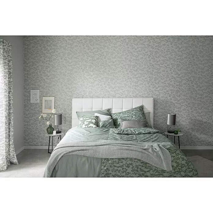 SCHÖNER WOHNEN-Kollektion New Spirit Vliestapete Blüten-Allover - Beige/Blau, Floral, 10,05 x 0,53 m - Schlafzimmer mit hellgrün gemusterter Tapete, Vorhängen und Bettwäsche.
