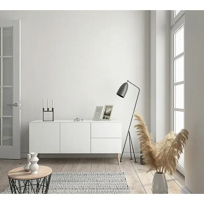 Marburg Sand & Stones Vliestapete Shades - Weiß, Uni, 10,05 x 0,53 m - Elegantes Sideboard in Weiß mit minimalistischem Design, ergänzt durch eine stilvolle Stehlampe und dekorative Elemente.
