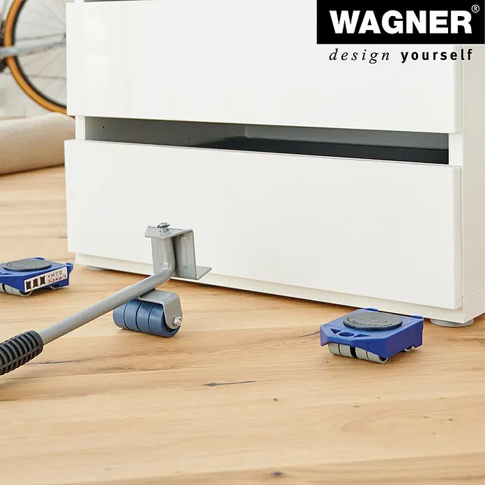 Wagner System Transportroller MM 3121 - Traglast: 150 kg, Stahl - Möbelroller-Set im Einsatz unter einem weißen Schrank, erleichtert das Verschieben schwerer Möbelstücke auf Holzböden.