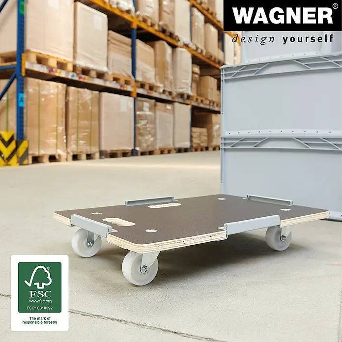 Wagner System Transportroller MM 1381 - L x B x H: 640 x 440 x 100 mm, Traglast: 250 kg, Holz - Eine Möbelroller mit einem Tragegriff und vier Rollen vor einem Lagerhintergrund. Das Produkt ist von WAGNER, „design yourself".