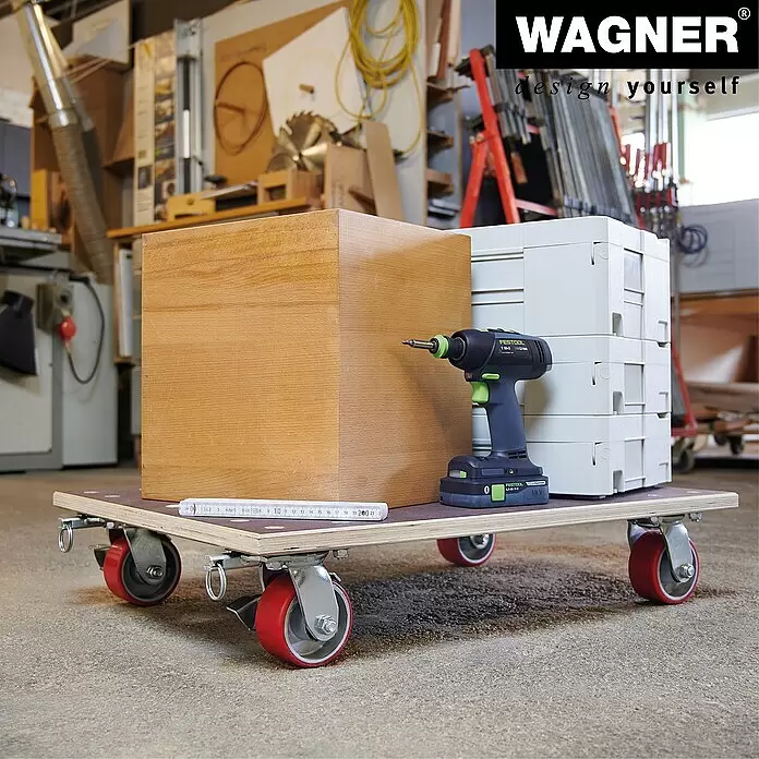 Wagner System Transportroller MM 1348 - L x B x H: 78 x 59 x 16 cm, Traglast: 1.000 kg, Holz - Rollbrett aus Sperrholz mit roten Rollen, beladen mit einer Holzkiste und Werkzeugen in einer Werkstatt.