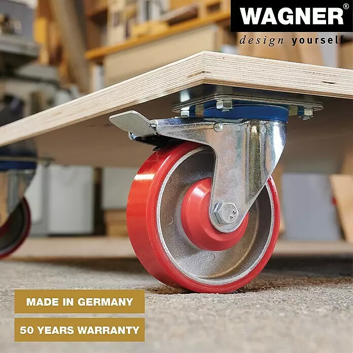 Wagner System Transportroller MM 1349 - L x B x H: 1.200 x 800 x 177 mm, Traglast: 1.000 kg, Holz - Rotes und silbernes Lenkrolle mit Bremse an einem Holzrollbrett, zum Bewegen von Gegenständen in einer Werkstatt.