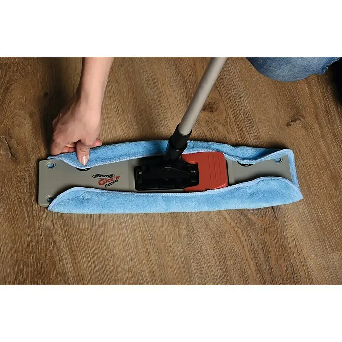 Sprintus Bodenwisch-Set Click N Press + Staubmop - 12 l, 5 -tlg., Materialzusammensetzung Bezug: 80 % Mikrofaser, 20 % weiche Abrasivborsten - Das Bild zeigt einen Spritus Click’N’Press Mopp mit blauem Mikrofaserbezug, der auf einem Holzboden liegt und von einer Hand bedient wird.