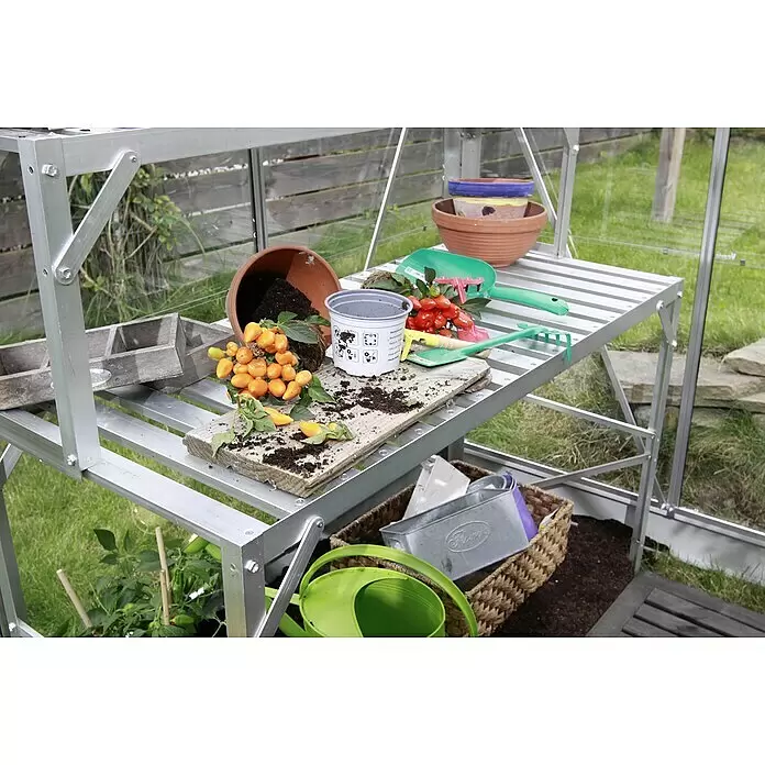 Vitavia Anzuchttisch I - 54 x 121 x 76 cm, Aluminium - Silbernes Aluminium-Gewächshausregal mit Gartenbedarf, einschließlich Töpfen, Erde und Werkzeugen, in einem Gewächshaus.