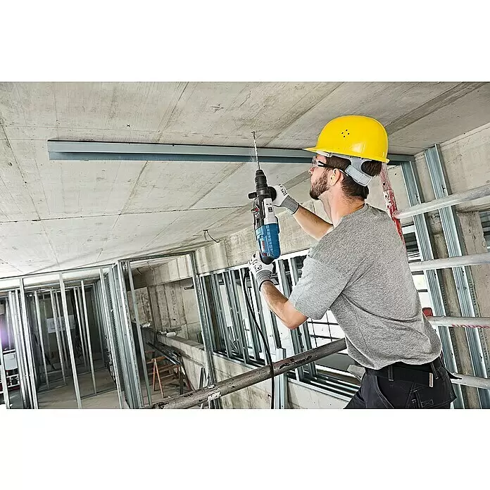 Bosch Professional Kombihammer GBH 2-28 F - 880 W, 3,2 J, SDS-Plus-Aufnahme, Ohne Bohrer & Meißel - Mann mit Schutzhelm und Schutzausrüstung bohrt mit einem Bohrhammer in eine Betondecke.