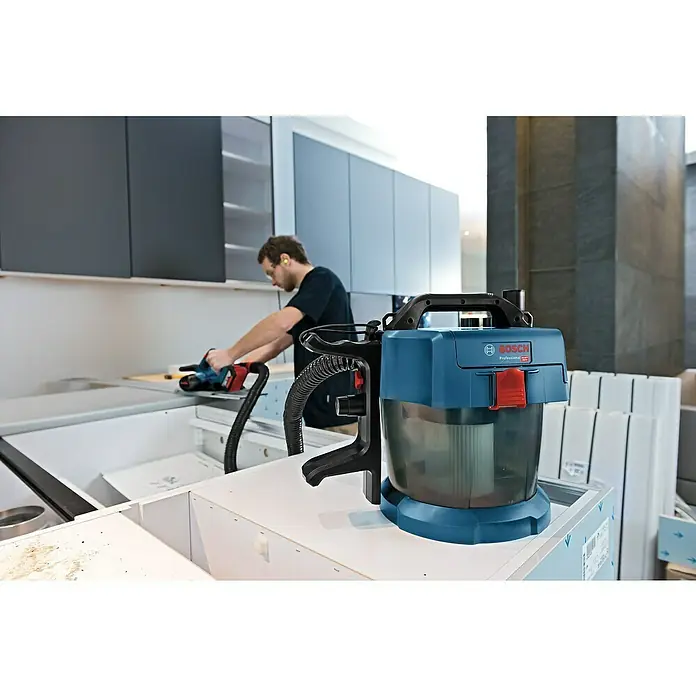 Bosch Professional AMPShare 18V Akku-Nass-Trockensauger GAS 18V-10 L Kit - 18 V, Ohne Akku, Behältervolumen: 10 l - Bild eines Bosch Professional Nass- und Trockensaugers mit dem Handwerker im Hintergrund, ideal für Baustellen und Werkstätten.