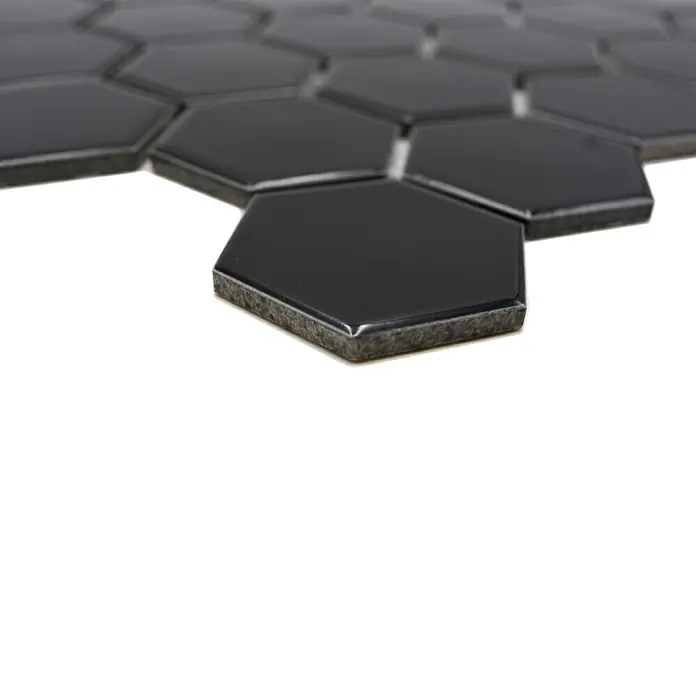 Mosaikfliese Hexagon Uni HX 090 - 32,5 x 28,1 cm, Schwarz, Glänzend - Nahaufnahme von schwarzen, sechseckigen Wandfliesen, die eine glatte, moderne Textur für Innenräume bieten.