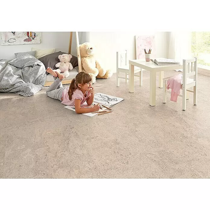 Corklife Studiostyle Korkboden - Abrantes Weiß, 905 x 295 x 10,5 mm - Heller, strukturierter Bodenbelag in einem Kinderzimmer, auf dem ein Mädchen malt, betont seine Haltbarkeit und spielfreundliche Oberfläche.