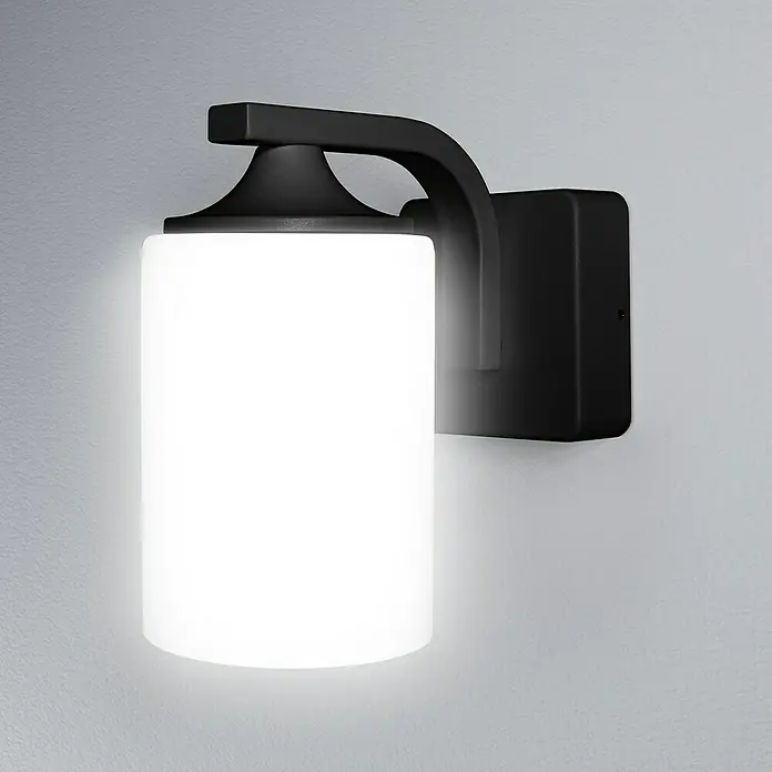 Osram LED-Außenwandleuchte - 210 x 11,8 x 21,2 cm, Aluminum, IP43 - Nahaufnahme einer modernen schwarzen Wandleuchte mit einem zylindrischen, weißen Lampenschirm, die ein helles, diffuses Licht ausstrahlt.