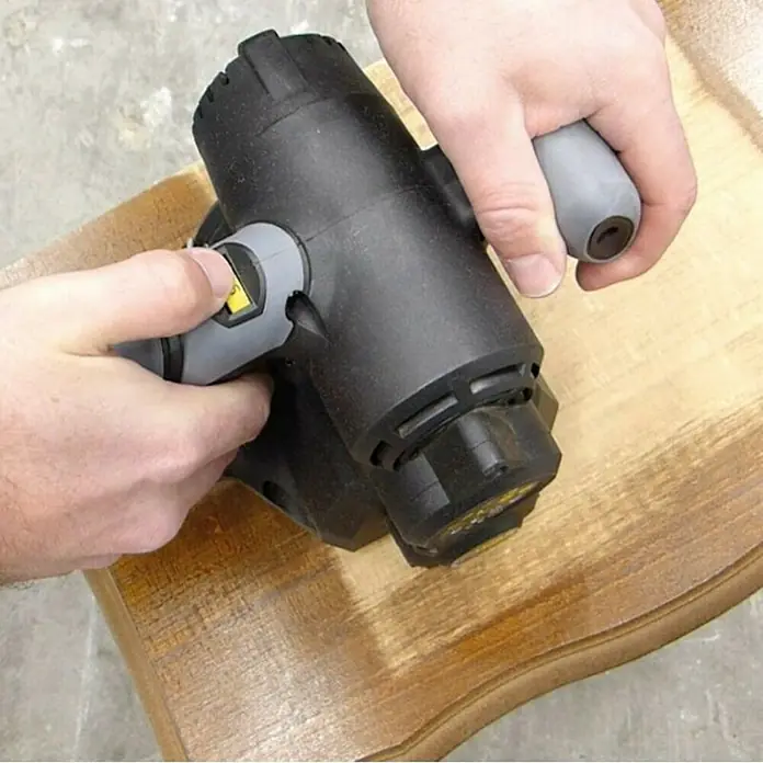 Fartools Desbastadora Renovator REX 80 Compact - 420 W - Primer plano de una persona que usa un fregador eléctrico sobre un trozo de madera, posiblemente limpiando o puliendo.