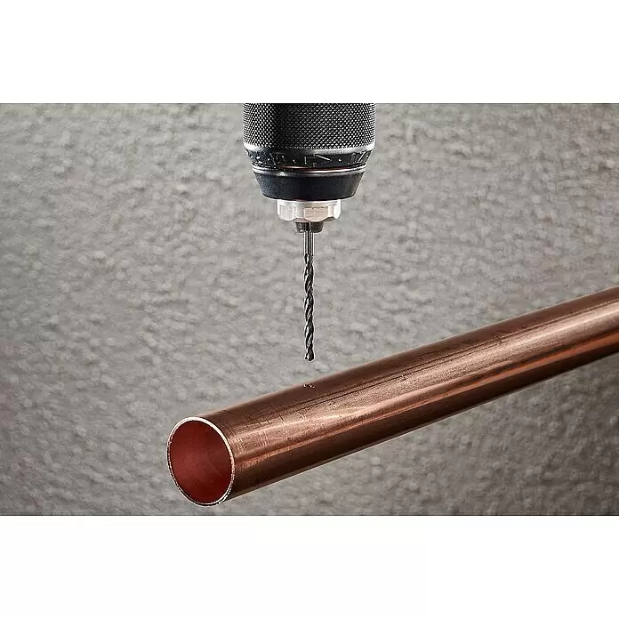 Wolfcraft Metallbohrer rollgewalzt - 1 Stk., Durchmesser Bohrer: 5 mm - Bohrer im Bohrfutter über einem Kupferrohr, bereit zum Bohren.