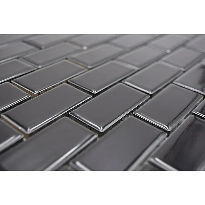 Mosaikfliese Brick Uni CBR 4BG - 29,8 x 29,8 cm, Schwarz, Glänzend - Nahaufnahme von glänzenden, grauen Metrofliesen, die ein modernes, fischgrätenartiges Muster bilden, ideal für stilvolle Wandverkleidungen in Küche und Bad.