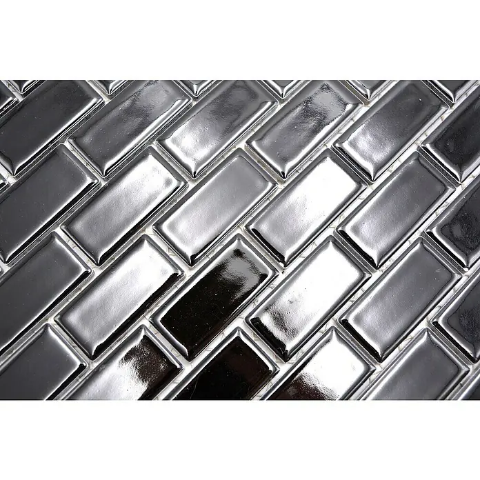 Mosaikfliese Brick Uni CBR 4BG - 29,8 x 29,8 cm, Schwarz, Glänzend - Nahaufnahme von rechteckigen, metallisch glänzenden Fliesen, die im Fischgrätmuster angeordnet sind und ein modernes Design zeigen.