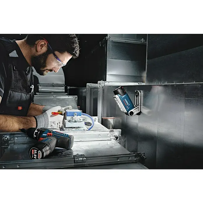 Bosch Professional Akku-Lampe GLI 12V-330 - 12 V, Ohne Akku, Lichtstrom: 330 lm - Handwerker bei der Arbeit mit dem Bosch Akku-Bohrschrauber und der Bosch Akku-Lampe zur präzisen Ausleuchtung des Arbeitsbereichs.