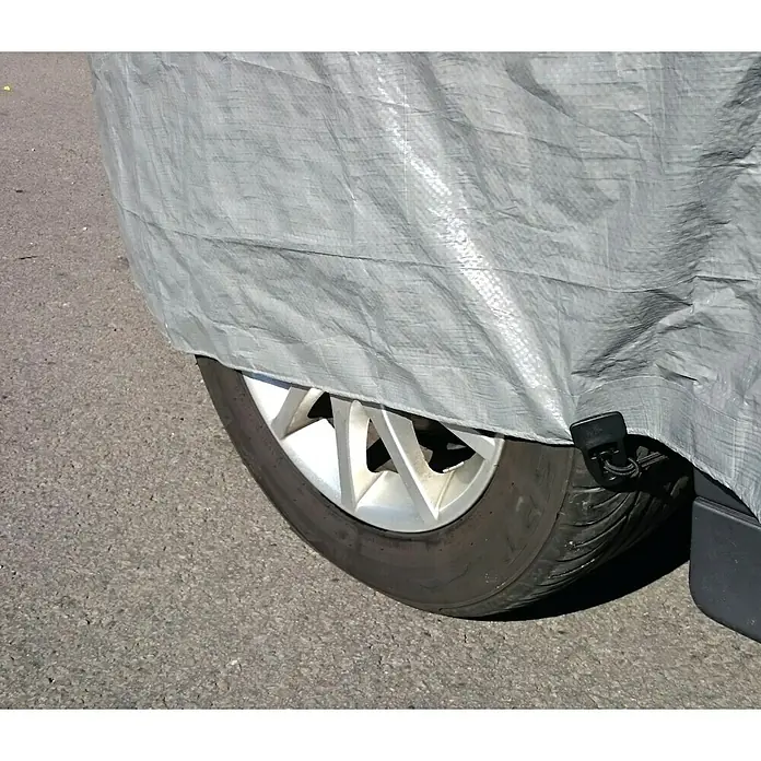 Clips Holdon Midi - 4 Stk., Schwarz - Nahaufnahme einer grauen Autoabdeckung, die einen Reifen und eine Felge verdeckt und das Fahrzeug vor Witterungseinflüssen schützt.