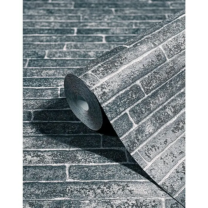 Marburg Sand & Stones Vliestapete Steinmauer I - Dunkelgrau, Steinoptik, 10,05 x 0,53 m - Nahaufnahme einer Rolle grauer Ziegelstein-Tapete, die das realistische Mauerwerk-Design und die Textur des Produkts hervorhebt.