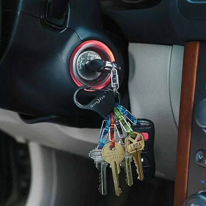 Nite Ize Mosquetón KeyRack - L x An: 12 x 2 mm, Acero inoxidable - Llaves de coche en un llavero Nite Ize con clips de colores, insertadas en el encendido iluminado de un coche.