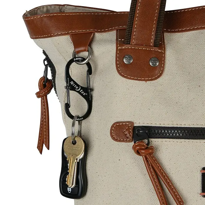 Nite Ize Doppelkarabiner S-Biner Slidelock - L x B: 104 x 13 mm, Edelstahl, Schwarz - Schlüsselanhänger mit einem Nite Ize S-Biner Doppelkarabiner an einer Tasche befestigt, praktische Accessoires für den Alltag.