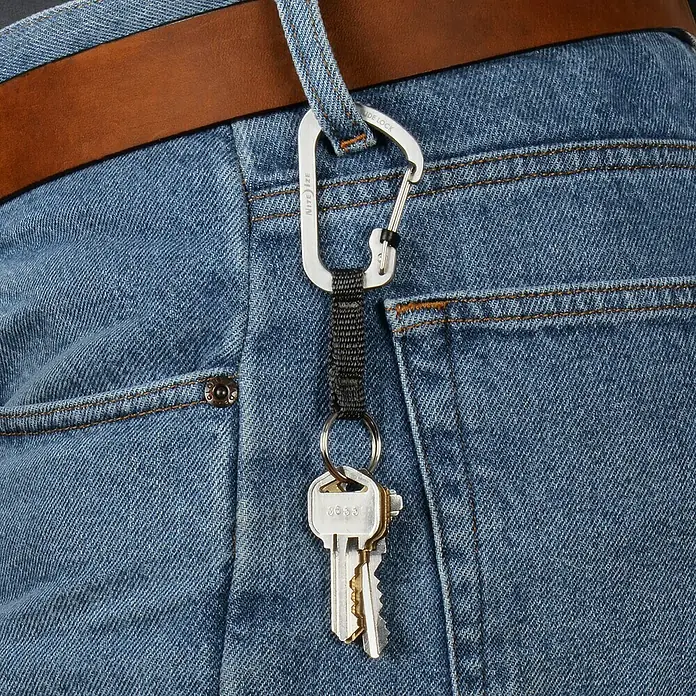 Nite Ize Karabinerhaken Slidelock Key Ring - Edelstahl, Silber - Schlüsselbund mit Karabinerhaken an Jeans befestigt. Schlüsselanhänger mit Nite Ize Sidelock Karabiner und Schlüsseln an einem Hosenbund.