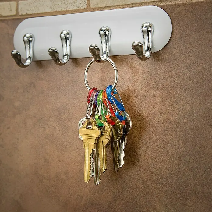 Nite Ize Karabinerhaken S-Biner KeyRing - L x B: 57 x 14 mm, Edelstahl - Schlüsselbund hängt an einem Wandhaken. Der Haken ist weiß mit vier silbernen Haken zum Aufhängen von Schlüsseln.