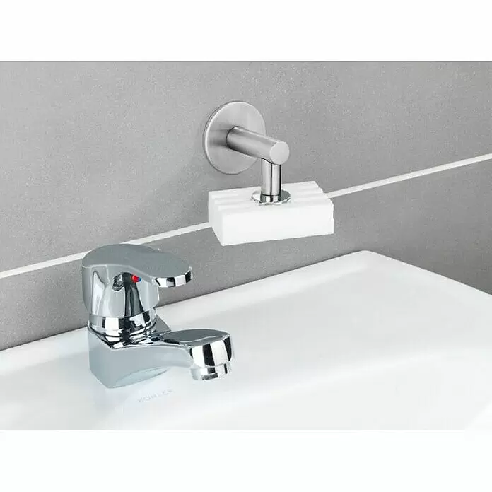 Wenko Magnetseifenhalter Turbo-Loc - Edelstahl, Matt - Wandmontierter Seifenhalter aus gebürstetem Metall mit weißer Seife über einem Waschbecken.