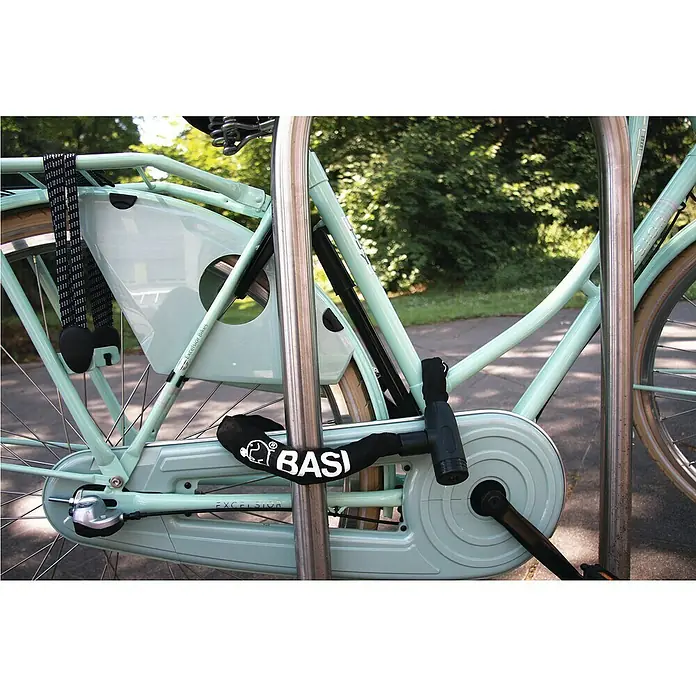 Basi Zahlen-Kettenschloss ZR 305 - Länge: 900 mm - Das Bild zeigt ein Fahrrad mit einem BASI-Kettenschloss, das um den Rahmen und einen Fahrradständer befestigt ist, um Diebstahl zu verhindern.