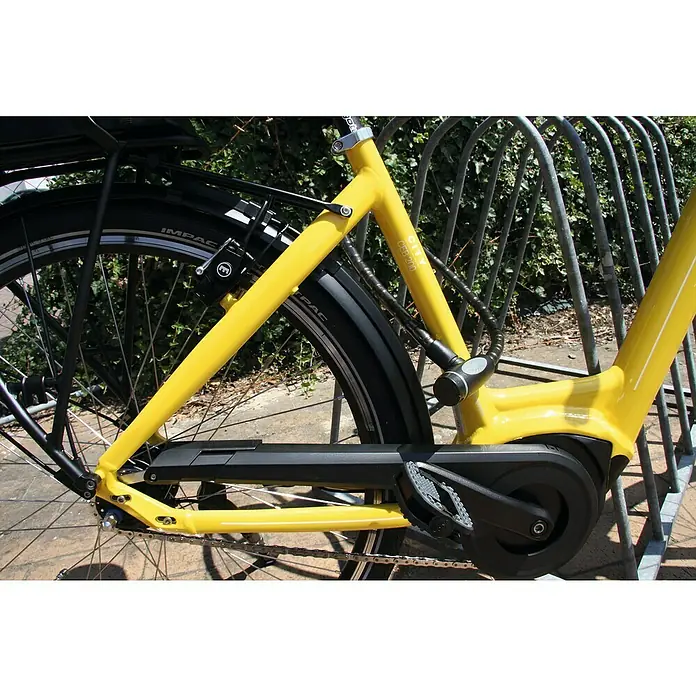 Basi Panzerseilschloss ZR 306 - Breite: 18 mm, Transparent - Gelbes Fahrrad der Marke City CEB 200, das mit einem schwarzen Kettenschloss an einem Fahrradständer befestigt ist.