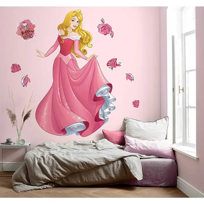Komar Dekosticker Aurora XXL - B x H: 127 x 200 cm - Dieses Bild zeigt eine Wanddekoration mit Prinzessin Aurora in einem rosa Kinderzimmer, die eine zauberhafte und märchenhafte Atmosphäre schafft.