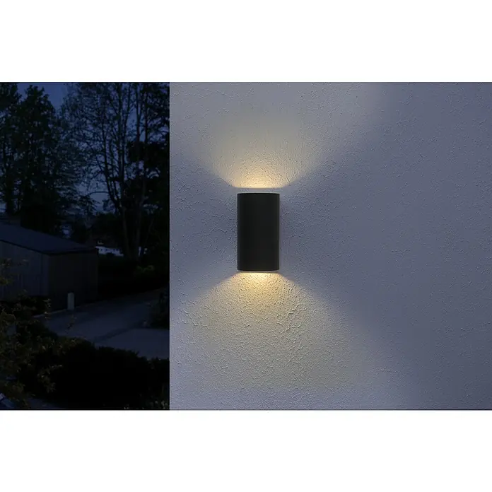 Ledvance LED-Außenwandleuchte Updown - 12 W, 5,5 cm x 9 mm x 16 cm, Anthrazit, IP44 - Eine moderne schwarze Wandleuchte strahlt warmes Licht nach oben und unten und beleuchtet eine strukturierte Wand in der Dunkelheit.