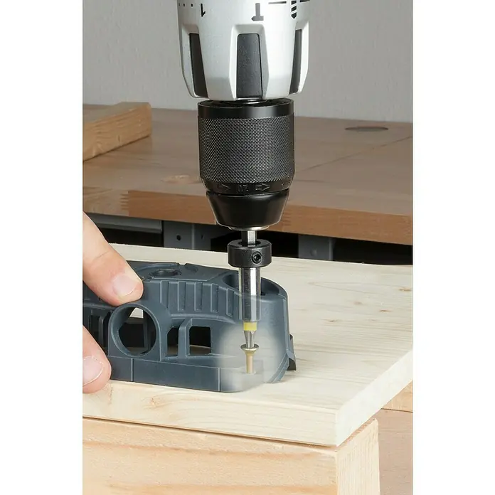 Wolfcraft Bohrhilfe - Lochdurchmesser: 35 mm - 12 mm - Eine Bohrmaschine mit Tiefenanschlag bohrt durch eine Bohrschablone in ein Holzbrett.