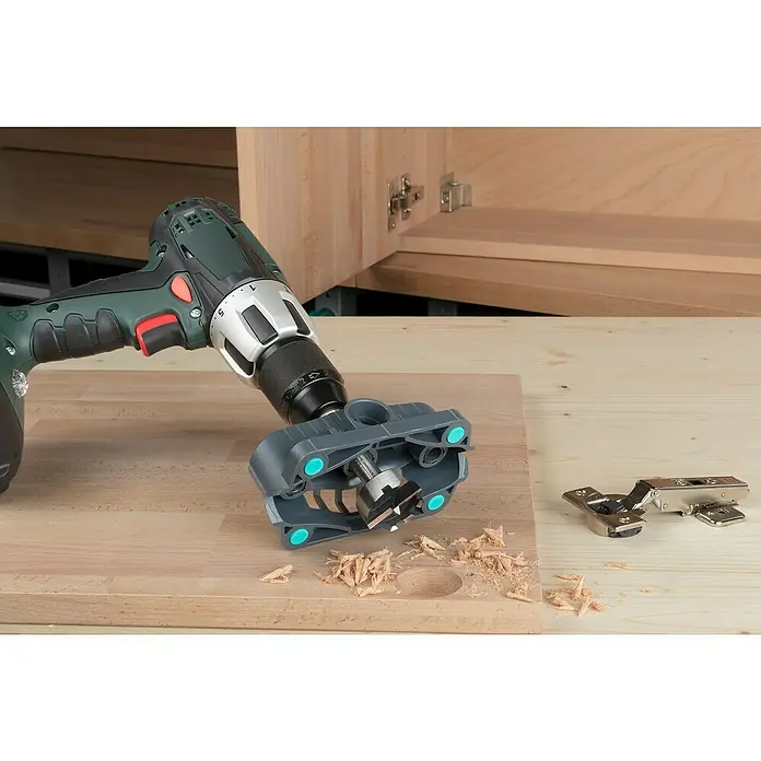 Wolfcraft Bohrhilfe - Lochdurchmesser: 35 mm - 12 mm - Eine Bohrmaschine mit Forstnerbohrer wird verwendet, um ein Loch für ein Scharnier in ein Holzstück zu bohren.