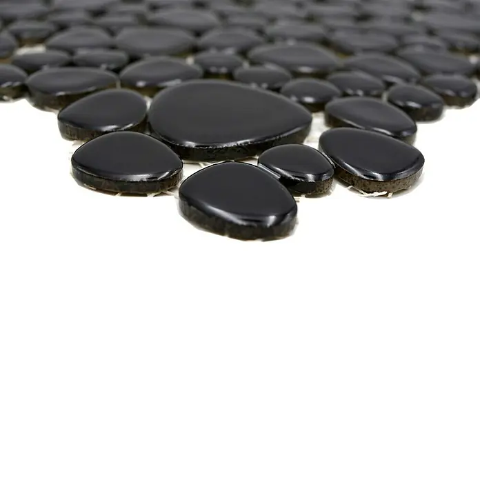 Mosaikfliese Kiesel Uni XKM 890N - 27,5 x 27,5 cm, Schwarz, Glänzend - Nahaufnahme eines Musters aus glänzenden, schwarzen Kieselsteinen, die auf einer hellen Oberfläche angeordnet sind. Perfekt für dekorative Zwecke.
