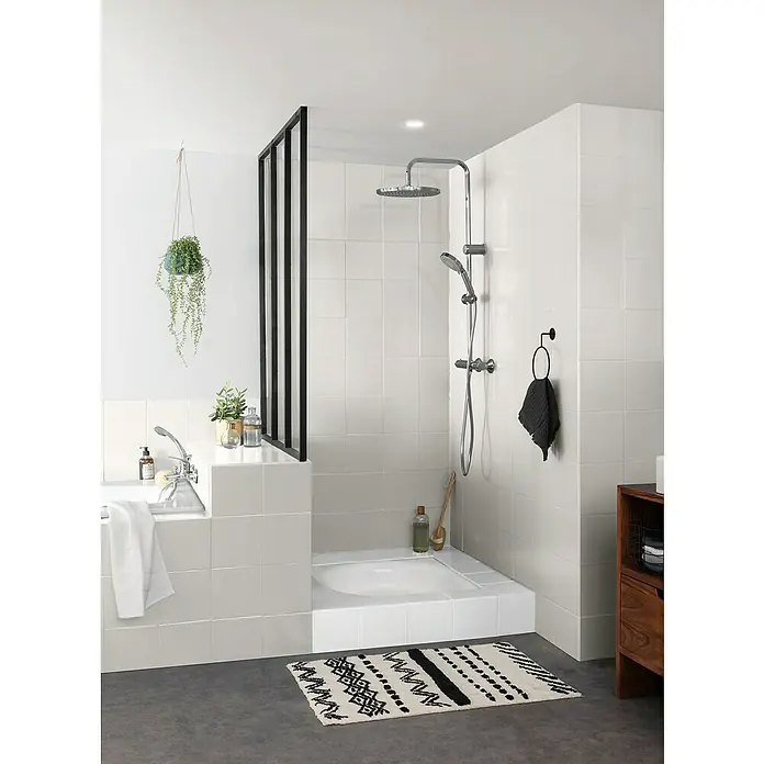 V33 Esmalte para azulejos Renovation Perfection - Lino, 750 ml, Satinado - Un baño moderno con azulejos blancos, una mampara de ducha con marco negro y una alfombra estampada para un ambiente elegante.