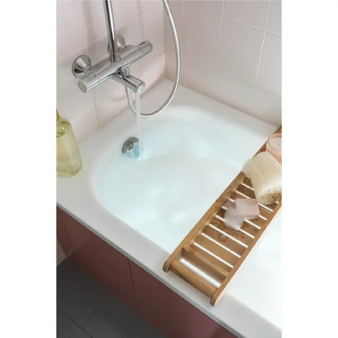 V33 Esmalte para azulejos Renovation Perfection - Blanco algodón, 75 ml, Satinado - Una lujosa experiencia de baño con una bandeja de madera para bañera, jabón, esponja y vela encendida junto a una bañera que se llena de agua.