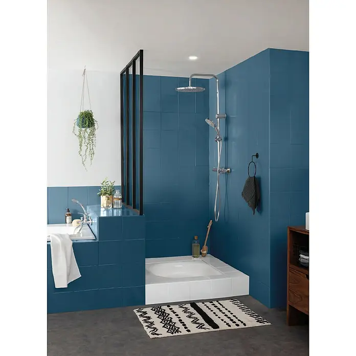 V33 Esmalte para azulejos Renovation Perfection - Azul profundo, 75 ml, Satinado - Elegante baño con azulejos azules, una ducha moderna y una bañera elegante. La alfombra y las plantas añaden un toque acogedor al espacio.