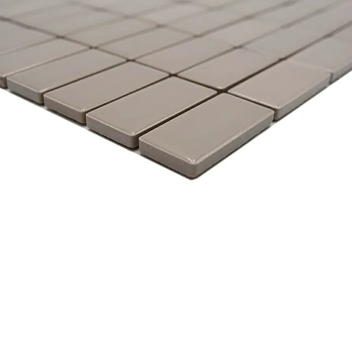 Mosaikfliese Stäbchen Uni ST 410 - 29,8 x 29,8 cm, Beige/Braun, Glänzend - Nahaufnahme eines Musters aus rechteckigen, hellbraunen Mosaikfliesen. Die glänzende Oberfläche der Fliesen reflektiert das Licht.