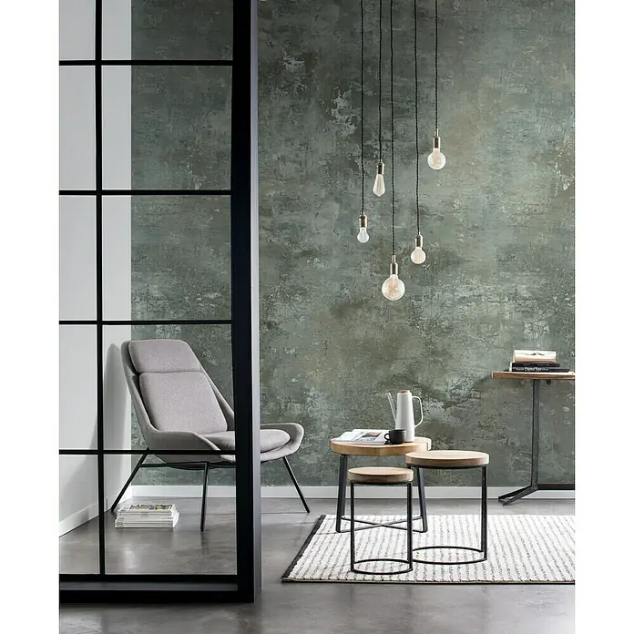 Rasch Factory 4 Fototapete Digitaldruck - 212 x 300 cm, Grün - Ein stilvolles Interieur mit einem grauen Sessel, Holzhockern und einer Pendelleuchte vor einer strukturierten Wand. Gemütliches Ambiente.