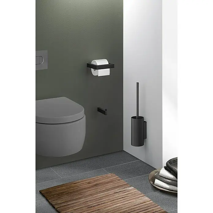 Zack Linea Toilettenpapierhalter - Ohne Deckel, Schwarz, Matt - Das Bild zeigt eine moderne Toilette mit einem schwarzen Toilettenpapierhalter und einer Toilettenbürste an der Wand.
