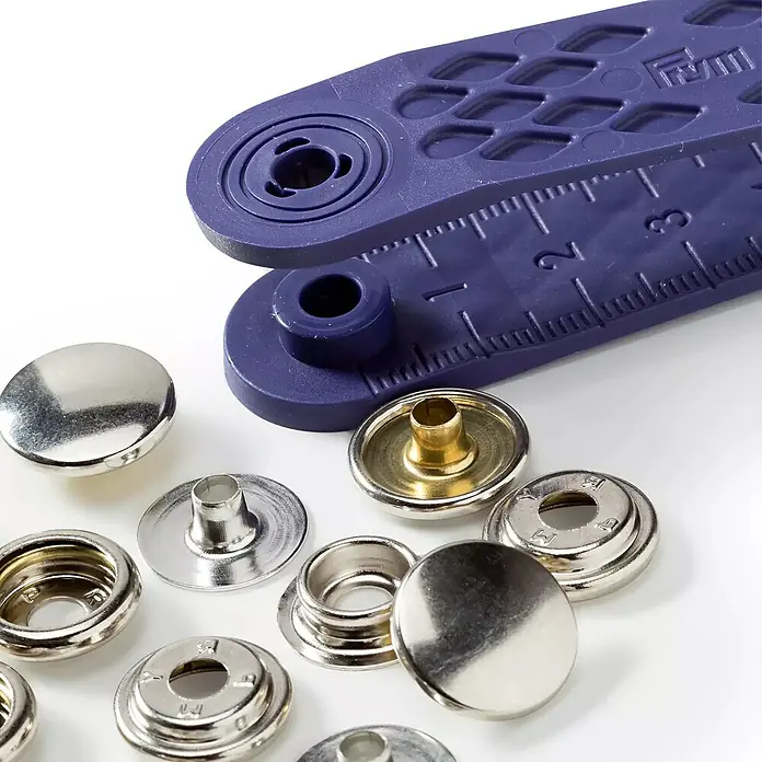 Seilflechter Cierre giratorio Sport & Camping - Latón, 10 ud. - Broches de presión metálicos plateados y dorados con una herramienta de plástico morado para colocarlos, que incluye una regla.