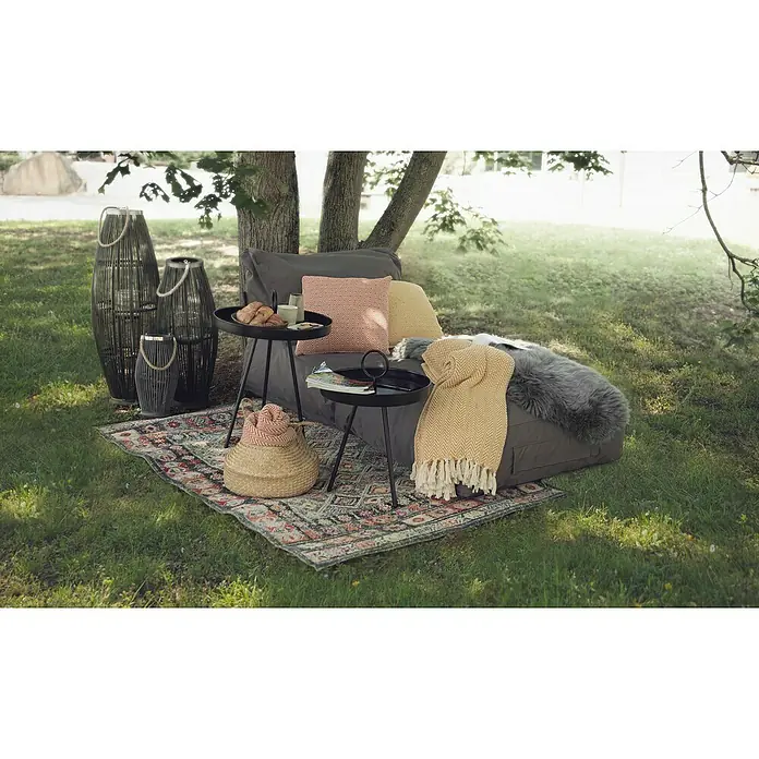 Beistelltisch mit Griff - Ø x H: 40 x 60 cm, Schwarz, Metall - Im Freien entspannen mit gemütlichen Kissen, Decken und Laternen auf einem gemusterten Teppich unter einem Baum.