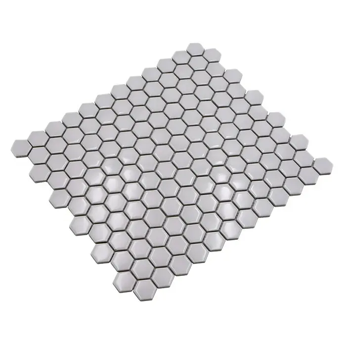 Mosaikfliese Hexagon Uni HX 050 - 26 x 30 cm, Weiß, Glänzend - Nahaufnahme eines Musters aus weißen, sechseckigen Keramikfliesen auf einer schwarzen Oberfläche.