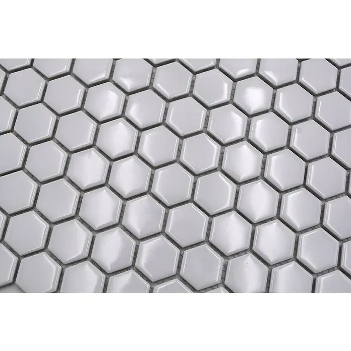 Mosaikfliese Hexagon Uni HX 050 - 26 x 30 cm, Weiß, Glänzend - Dieses Bild zeigt eine Nahaufnahme von weißen, glänzenden, sechseckigen Mosaikfliesen, die eng aneinander liegen und ein modernes Muster bilden.