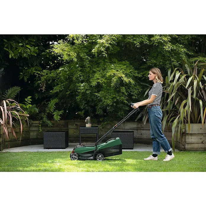 Bosch Power for All 18V Akku-Rasenmäher CityMower 18V-32-300 - 18 V, Ohne Akku, Schnittbreite: 32 cm - Frau benutzt einen grünen Rasenmäher im Garten, um das Gras zu schneiden. Der Rasenmäher ist das Hauptprodukt im Bild.