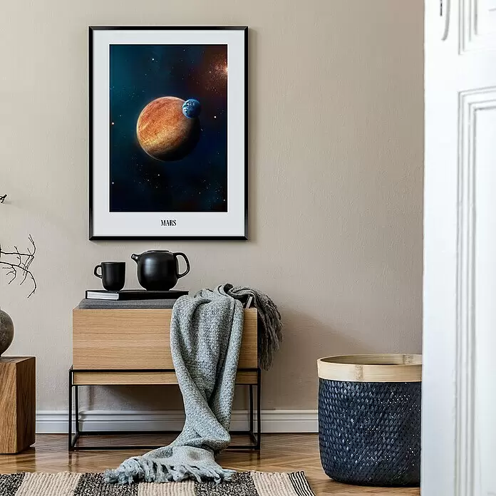 Bild Artbox - Mars, B x H: 50 x 70 cm - Gerahmtes Poster mit Mars und Erde im Weltraum, beschriftet mit 'MARS', an einer hellbraunen Wand über einem Holztisch.