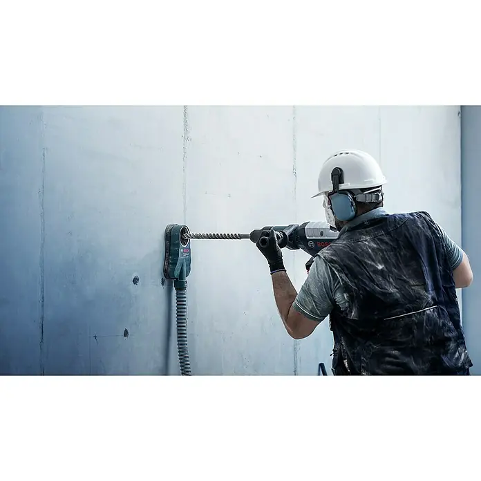 Bosch Expert Beton- & Steinbohrer SDS Plus-7X - 1 Stk., Durchmesser Bohrer: 6 mm, 150 mm - Ein Bauarbeiter bohrt mit einer Bosch Bohrhammer in eine Wand, wobei ein Staubabsaugungsaufsatz verwendet wird.