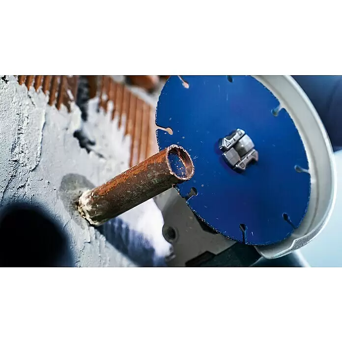 Bosch Expert Karbid-Trennscheibe Carbide Multi Wheel X-Lock - Durchmesser: 125 mm, 1 Stk. - Ein Winkelschleifer mit blauer Trennscheibe neben einem rostigen Kupferrohr in einer Betonwand.