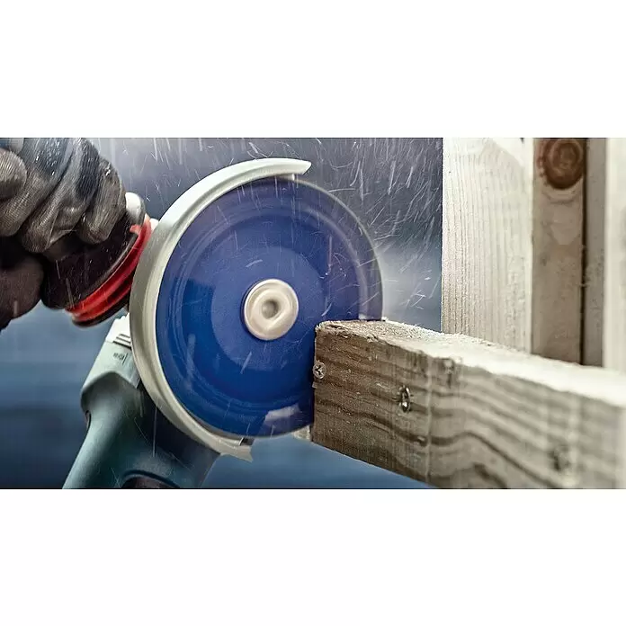 Bosch Expert Karbid-Trennscheibe Carbide Multi Wheel X-Lock - Durchmesser: 125 mm, 1 Stk. - Eine behandschuhte Hand bedient einen Winkelschleifer mit blauer Trennscheibe, der Funken sprüht beim Schneiden eines Holzträgers.